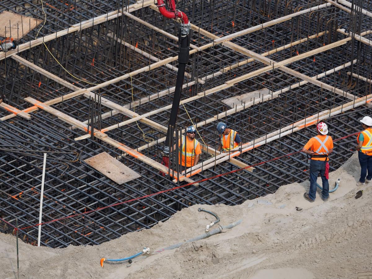 An elevated view of a crew placing reinforcement across a deck