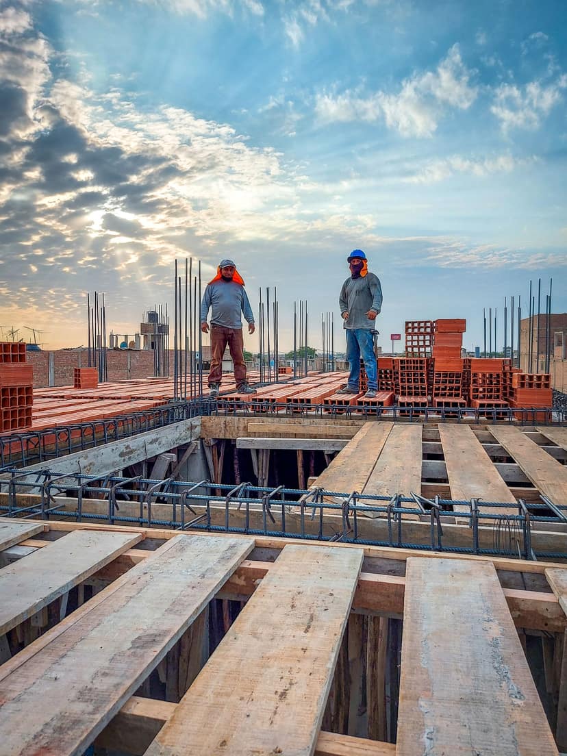 Two workers on a formed deck early in the morning