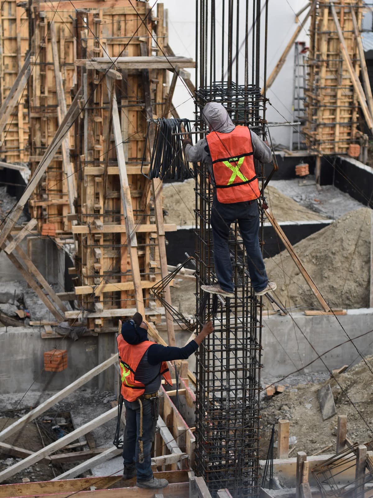 Workers tying reinforcement inside column formwork